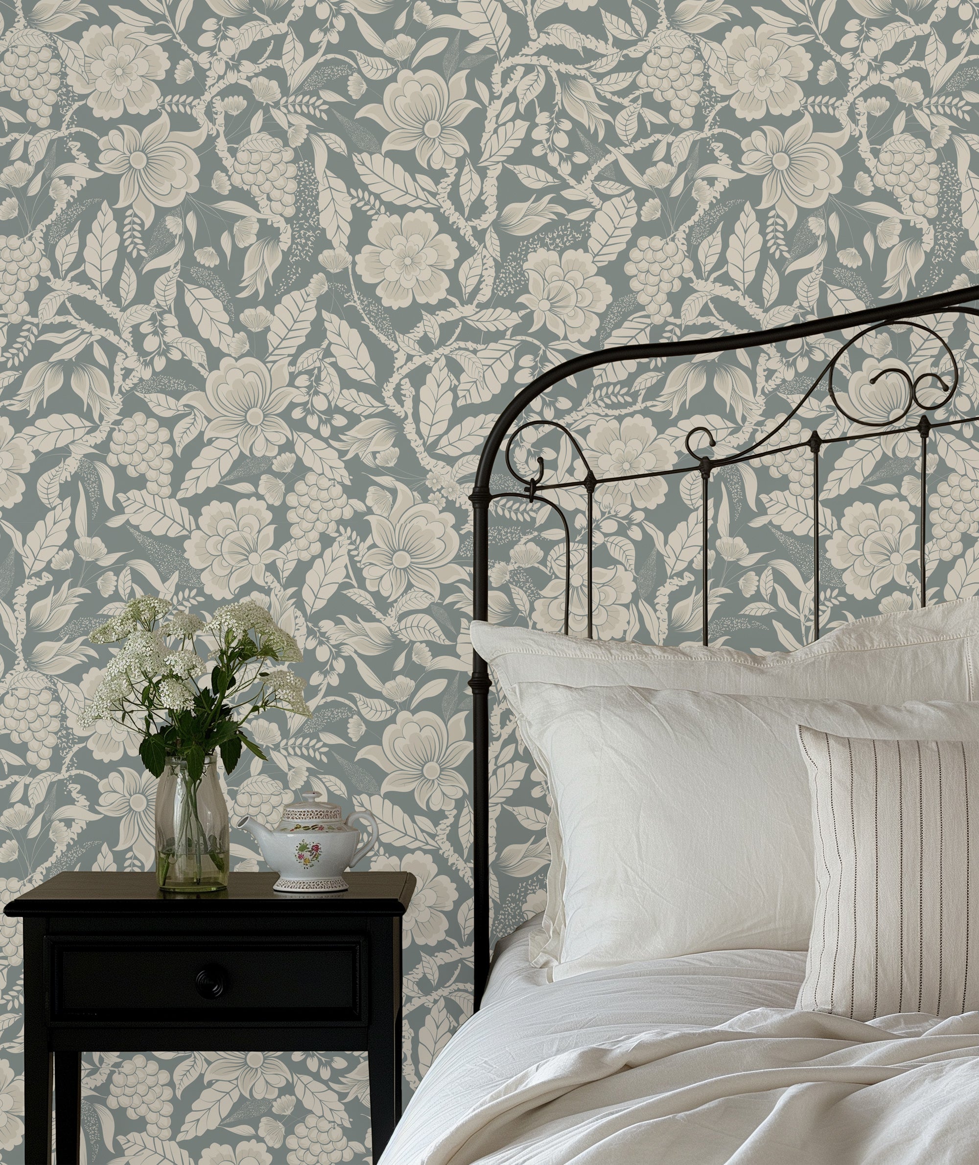 Bedroom with floral wallpaper, black metal bed frame, and white bedding.